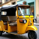 Tuk tuk jaune garé dans une rue pavée d'une ville de province française avec des façades colorées en arrière-plan
